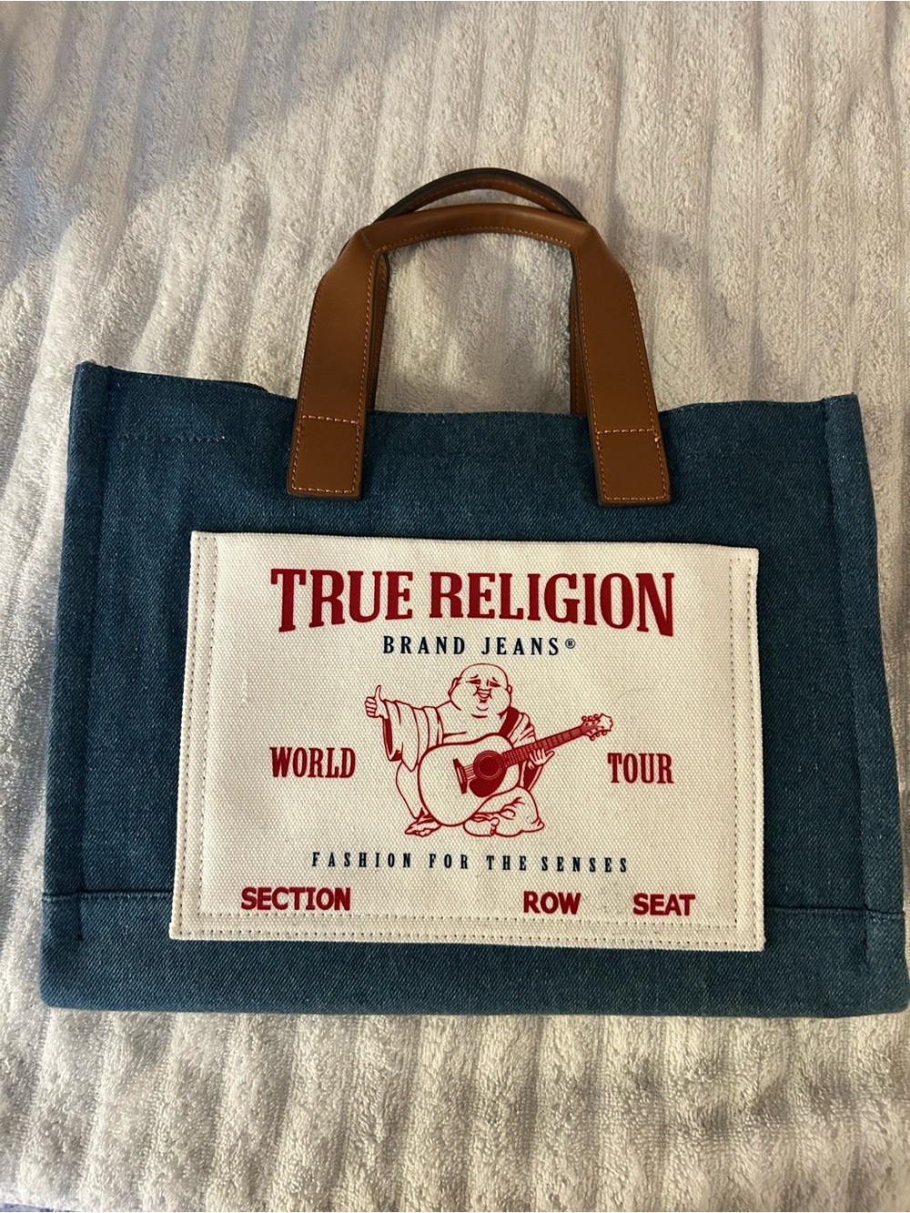 True Religion Blue Denim Messenger Bag with Brown Handles and Red Logo Patch